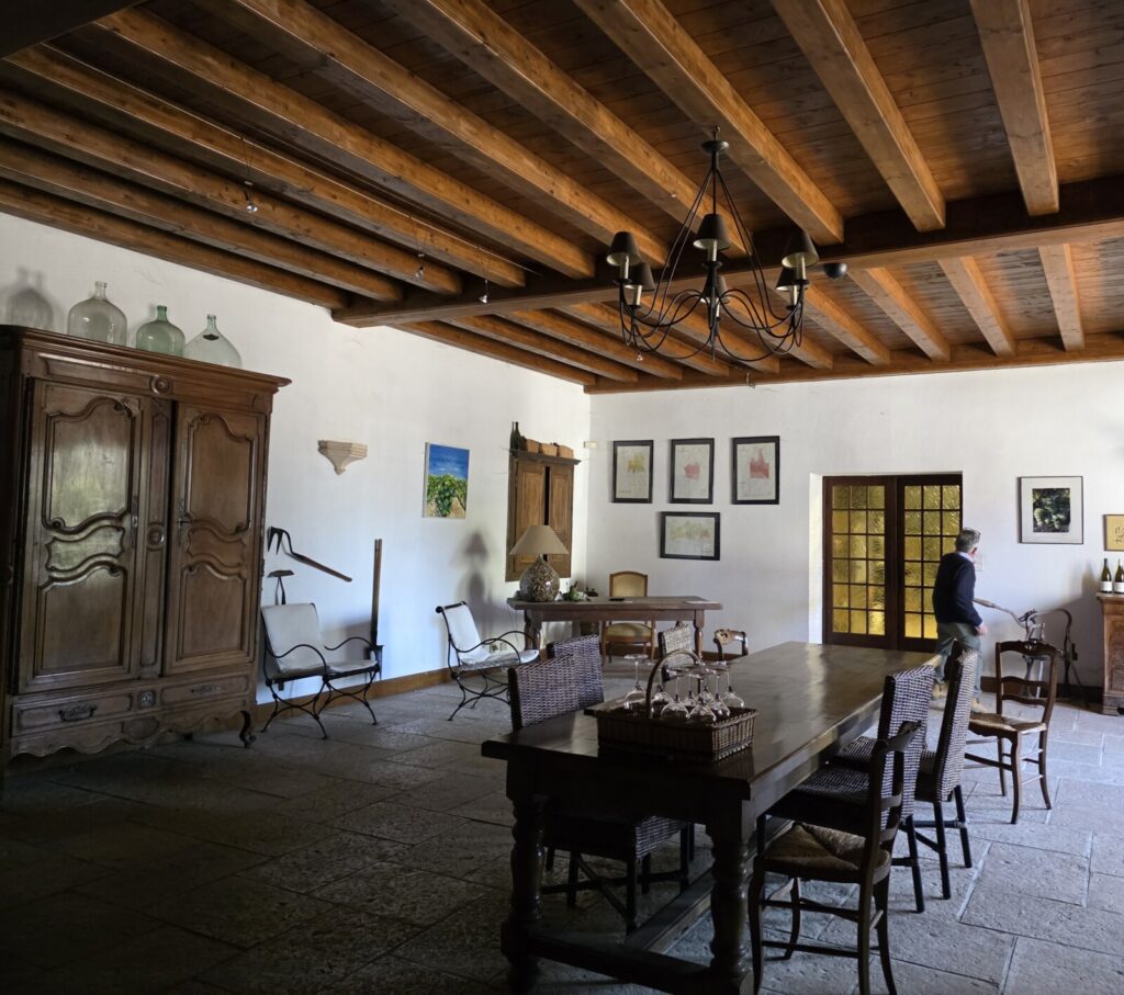 The historic interior of a French building with a wooden roof, white walls and antique furniture.