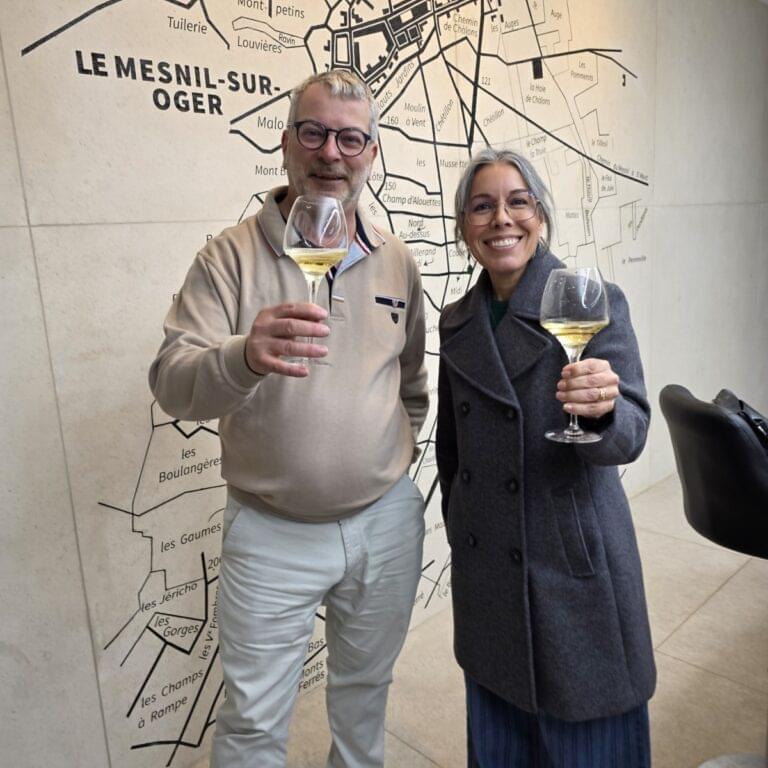Two people holding wine glasses and smiling.