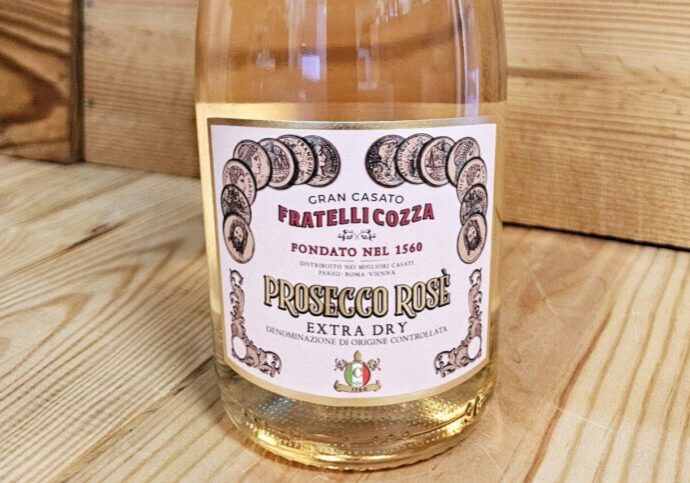 A bottle of Fratelli Cozza NV Prosecco Rosé Extra Dry resting against a wooden background.