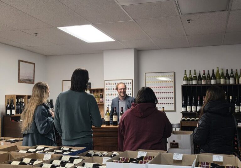 A wine tasting occurring at a counter.
