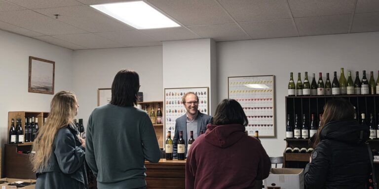A wine tasting occurring at a counter.